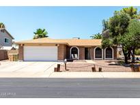 Charming single-story brick home featuring a well-maintained yard and a two-car garage at 5302 W Poinsettia Dr, Glendale, AZ 85304