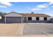 Charming single-story home featuring a gray garage door and a low-maintenance front yard at 7008 W Sierra St, Peoria, AZ 85345