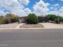 Charming single-story home featuring mature landscaping and a covered carport at 901 S Esperanza Ave, Mesa, AZ 85208