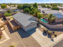 An aerial view of a single-Gathering home with a pool, a well-maintained yard, and a gray tile roof at 9422 W Monroe St, Peoria, AZ 85345