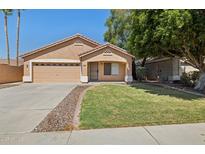 Charming single-Gathering home featuring a well-manicured lawn, a two-car garage, and desert landscaping at 1156 N San Benito Dr, Gilbert, AZ 85234