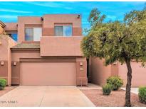 Two-story townhouse with a two-car garage, neutral tones, and desert landscaping in a well-maintained neighborhood at 1477 W Marlin Dr, Chandler, AZ 85286