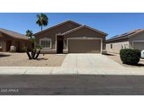 Charming single-story home with a desert landscape, a two-car garage and neutral-toned exterior paint at 15334 W Acapulco Ln, Surprise, AZ 85379