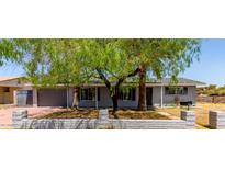 Charming single-story home featuring mature trees, a brick facade, and an attached garage at 17401 N 16Th Ave, Phoenix, AZ 85023