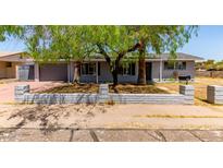 Charming single-story home with mature trees and a low brick wall enhancing the curb appeal at 17401 N 16Th Ave, Phoenix, AZ 85023