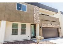Modern two-story townhome with mixed material facade featuring stone and an attached two-car garage at 2000 N 36Th St # 17, Phoenix, AZ 85008