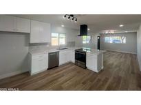 Bright kitchen features white cabinets, stainless steel appliances, and stylish tile backsplash at 2331 E Delgado St, Phoenix, AZ 85022