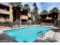 Inviting community pool with lounge chairs and lush landscaping at 2625 E Indian School E Rd # 115, Phoenix, AZ 85016