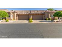 Inviting exterior view of townhome with a private two-car garage, manicured landscaping, and a charming tile roof at 4202 E Broadway Rd # 130, Mesa, AZ 85206