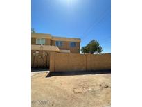 Beige two-story building featuring a secure perimeter wall and clear blue sky at 4236 S 46Th Pl, Phoenix, AZ 85040
