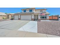 Two-story home featuring a three-car garage, well-kept gravel landscaping, and solar panels on the roof at 10806 W Adam Ave, Peoria, AZ 85373