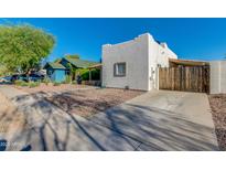 View of a quaint single-story home featuring a gravel yard and a covered parking area on a sunny day at 1409 E Apollo Rd, Phoenix, AZ 85042
