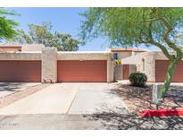 Exterior view of garage with red doors, desert landscaping, and neutral stucco at 1822 S River Dr, Tempe, AZ 85281