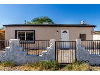 Charming single-story home featuring a secured front yard with decorative stone and wrought iron fencing at 1916 W Tonto St, Phoenix, AZ 85009