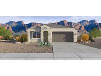 Charming single-story home featuring a two-car garage, desert landscaping, and a picturesque mountain backdrop at 24264 W Hacienda Ave, Buckeye, AZ 85326