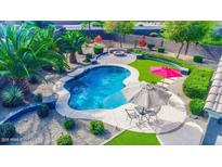 Backyard oasis with a sparkling pool, patio seating, lush landscaping and a charming fire pit for outdoor entertaining at 6731 S 37Th Dr, Phoenix, AZ 85041