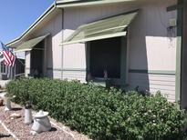 Charming exterior with well-maintained landscaping, patriotic American flags, and lovely awnings at 6960 W Peoria Ave # 156, Peoria, AZ 85345