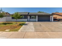 Charming single story home featuring a spacious driveway, lawn and a low white brick wall at 845 E Hampton Ave, Mesa, AZ 85204
