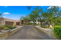 Desert landscaping and brick driveway lead to this charming, flat-roofed home with a two-car garage at 30600 N Pima Rd # 61, Scottsdale, AZ 85266