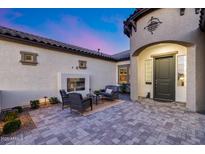 Private outdoor patio with a cozy seating area, fireplace and stylish hardscaping and lighting at 7415 W Lisbon Ln, Peoria, AZ 85381