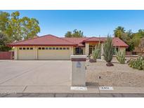 Charming single-story home with a red tile roof and three-car garage in a well-manicured desert landscape at 8511 W Via Montoya Dr, Peoria, AZ 85383