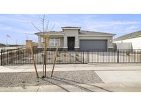 Charming single-story home featuring a well-maintained front yard with a fenced entrance and a two-car garage at 15348 W Gray Fox Trl, Surprise, AZ 85387