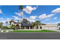 Charming single-story home with desert landscaping, mature palm trees, and a stucco exterior at 1905 N Calle Maderas --, Mesa, AZ 85213