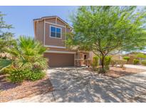Charming two-story home featuring desert landscaping, a two-car garage, and a welcoming entrance at 19771 W Woodlands Ave, Buckeye, AZ 85326