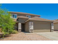 Inviting two-story home with a well-manicured yard and a classic brown color scheme at 22610 W Mohave St, Buckeye, AZ 85326