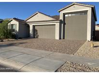 Charming single-story home with a well-manicured yard, a two-car garage, and stone accents in the driveway at 25657 N 185Th Dr, Surprise, AZ 85387