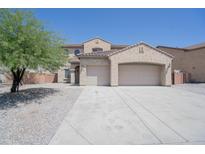 Lovely two-story home featuring an attached three-car garage and desert landscaping at 30268 W Sheila Ln, Buckeye, AZ 85396