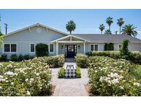 Charming single-story home featuring a symmetrical facade, gray siding, and a beautifully landscaped front yard with a small fountain at 4125 N 64Th St, Scottsdale, AZ 85251