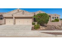 Charming home featuring a three car garage with neutral toned doors and desert landscaping in the front yard at 5107 N 194Th Dr, Litchfield Park, AZ 85340