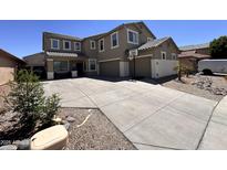 Two-story home features a three-car garage and a long driveway with basketball hoop at 10347 W Odeum Ln, Tolleson, AZ 85353