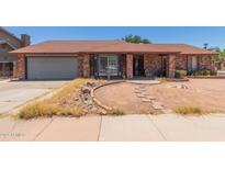 Charming single-story brick home featuring a bay window, attached garage, and well-lit entry way at 1123 W Mendoza Ave, Mesa, AZ 85210