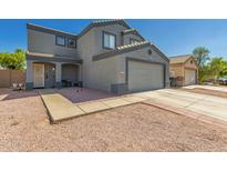 Two-story home with a two-car garage, neutral tones, desert landscaping, and covered front porch entry at 12325 W Dreyfus Dr, El Mirage, AZ 85335