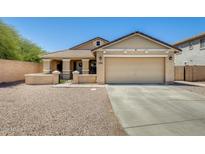 Charming single-Gathering home with a two-car garage, inviting front porch, and low-maintenance desert landscaping at 1397 E Laurel Pl, Casa Grande, AZ 85122