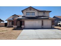 Two-story home featuring a brick garage, solar panels, and low-maintenance front yard at 17458 N 64Th Dr, Glendale, AZ 85308