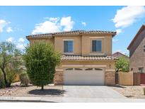 Two-story home with a tile roof, attached two-car garage, and a small tree in the front yard at 1753 N St Francis Pl, Casa Grande, AZ 85122