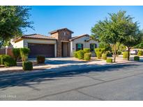 Charming single-story home featuring a desert landscape, stone accents, and a two-car garage at 19598 E Walnut Rd, Queen Creek, AZ 85142
