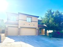 Inviting two-story home featuring a two-car garage, desert landscaping, and a charming, covered entryway at 2114 N 94Th Ave, Phoenix, AZ 85037