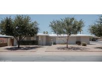 Charming single-story home featuring mature shade trees, a walkway, and desert landscaping at 5602 W Heatherbrae Dr, Phoenix, AZ 85031