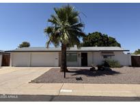 Charming home with a well-maintained front yard, three-car garage and desert landscaping at 6048 E Des Moines St, Mesa, AZ 85205