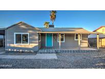 Charming single-story home featuring a covered porch and a bright blue front door at 11014 W Cocopah St, Avondale, AZ 85323
