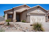 Charming single-story home featuring a well-maintained front yard with desert landscaping and a two-car garage at 1102 N 5Th St, Buckeye, AZ 85326