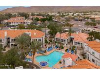 Beautiful aerial view of community pool, landscaping, and nearby neighborhood at 11375 E Sahuaro Dr # 2033, Scottsdale, AZ 85259