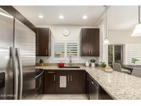 Modern kitchen features stainless steel appliances, granite countertops, and dark wood cabinetry at 14000 N 94Th St # 2187, Scottsdale, AZ 85260