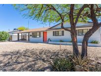 Charming single-story home featuring a white exterior, vibrant orange front door and desert landscaping at 3325 S Shafer Dr, Tempe, AZ 85282