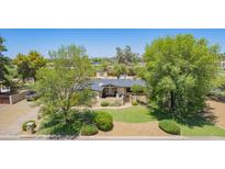 Charming single-story home featuring a well-manicured lawn and mature trees at 6330 E Delcoa Ave, Scottsdale, AZ 85254