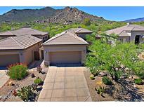 Desert home with a two-car garage and drought-resistant landscaping, including cacti and native plants at 6714 E Nightingale Cir, Scottsdale, AZ 85266